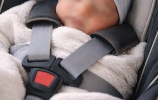 newborn baby in infant car seat during taxi journey home from hospital in London