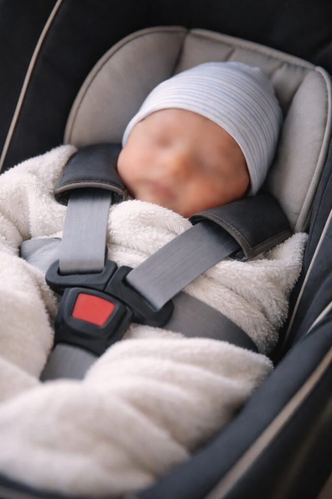 newborn baby in infant car seat during taxi journey home from hospital in London